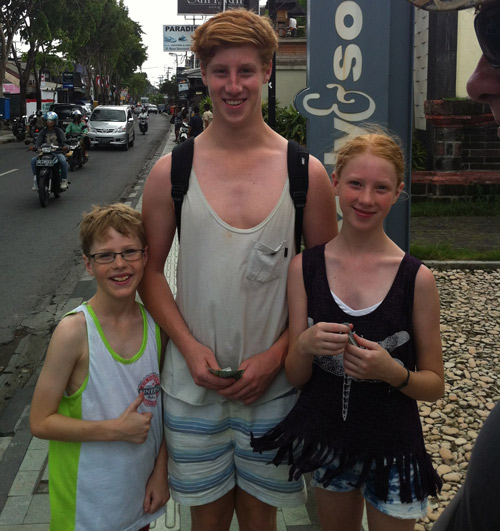 Lachlan standing with his two siblings before his injury. They are smiling . 